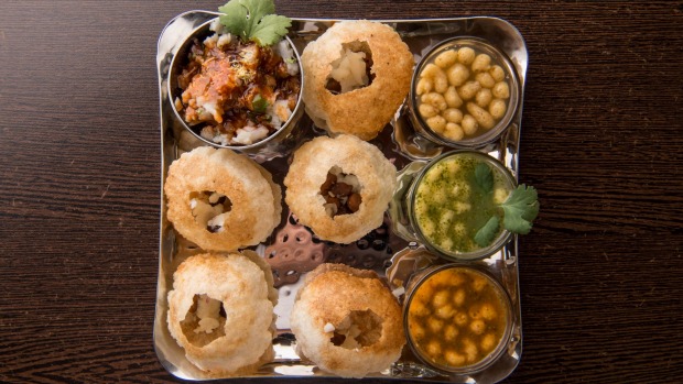 Pani puri,酥脆贝壳装满鹰嘴豆,土豆,楚奈斯和罗望子水。