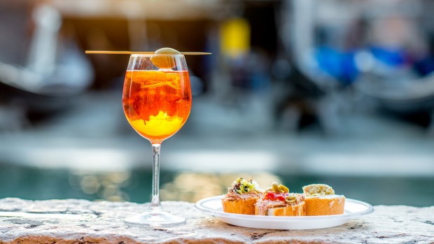 与cicchetti(传统venetian小吃)的aperol spritz在运河在威尼斯。
