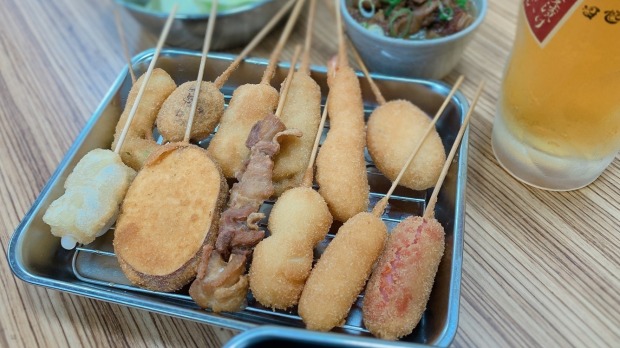 大阪的Daruma专门从事Kushikatsu:肉类,海鲜或蔬菜串,并炸到一个金色的紧缩。