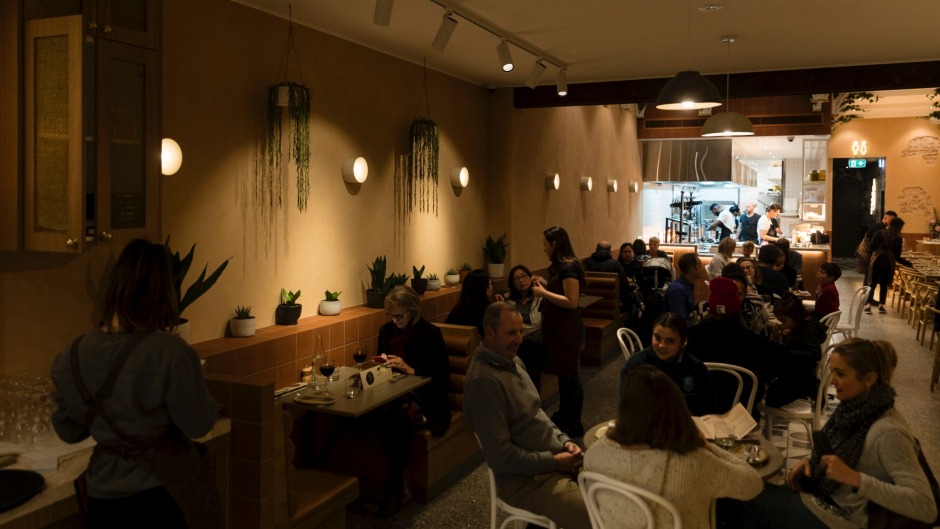 Lillah餐厅的用餐区从酒吧延伸到明亮的开放式厨房。