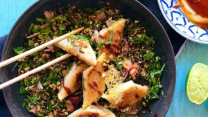 蕾丝陶瓷饺子在烤花椰菜，香草和腌制的姜沙拉上。