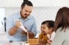 亚当·利亚（Adam Liaw）和他的家人在圣诞节姜饼屋里。