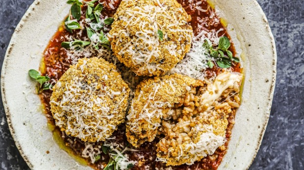 俗气的bolognese arancini在番茄酱中发挥作用。